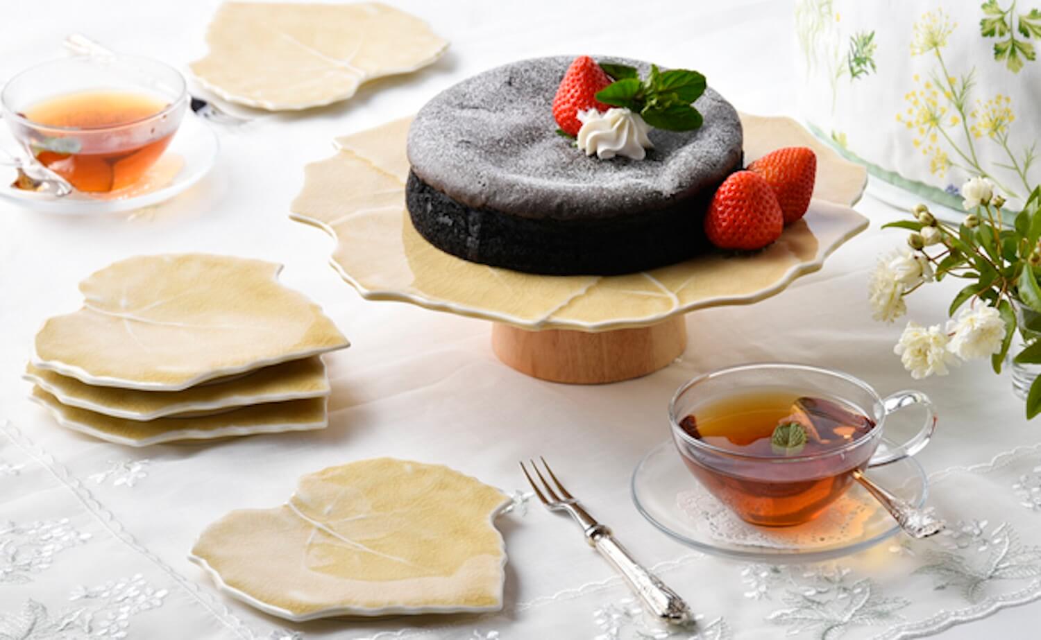 葉型のお皿にケーキを盛り、紅茶を添えた食卓